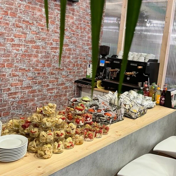 Catering-Buffet mit verschiedenen Speisen und einer Kaffeemaschine im Hintergrund